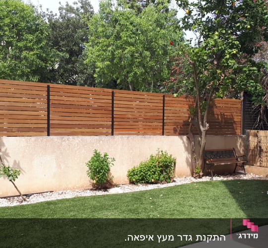 גדר עץ חומה עם עמודי מתכת בגינה